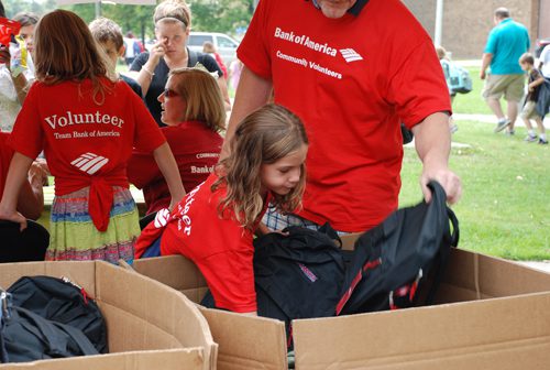 A child reaching for school supplies.