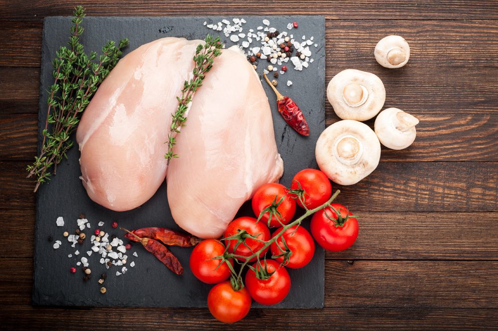 Chicken for grilled, spices, herbs, tomatoes, mushrooms on dark background, top view