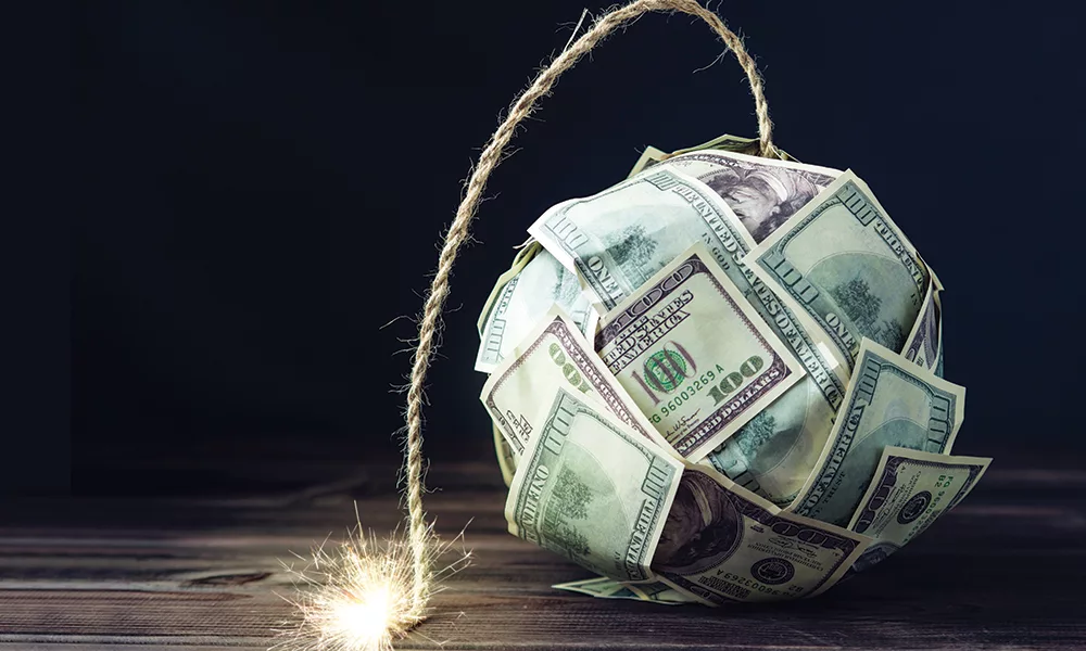 Bomb of money hundred dollar bills with a burning wick. Little time before the explosion. Concept of financial crisis