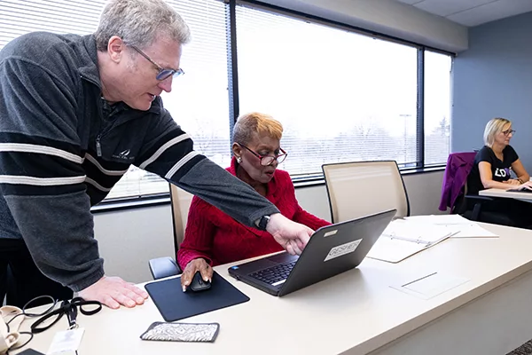 David Rotter assisting a student while teaching a computer class at Gesher Human Services